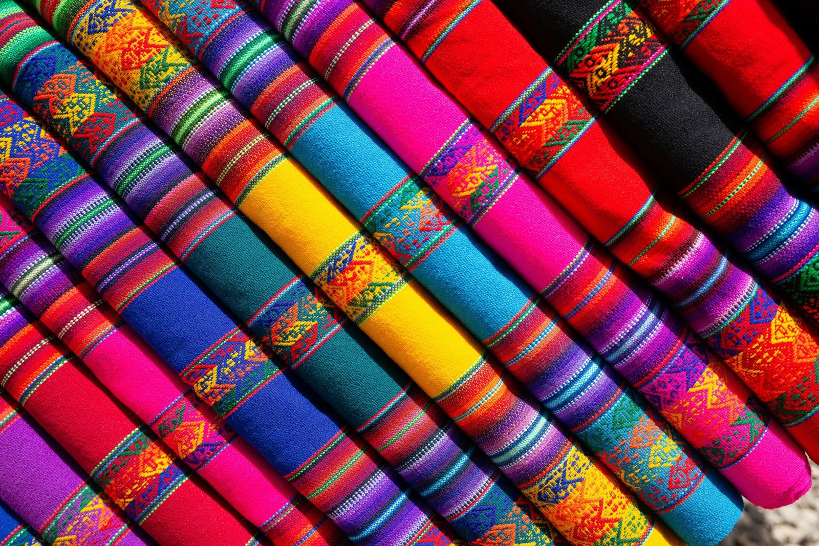 Colorful traditional woven fabrics with intricate patterns in vibrant hues.
