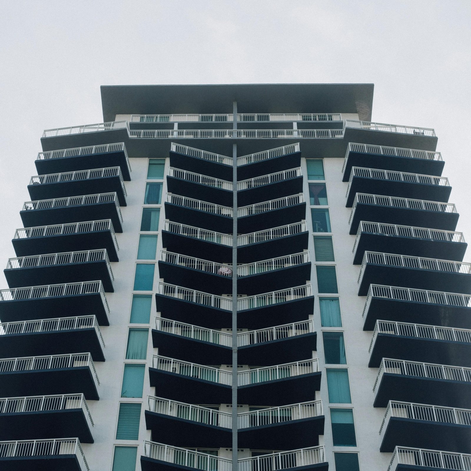 Contemporary skyscraper with glass facade and balconies, showcasing urban architectural elegance.